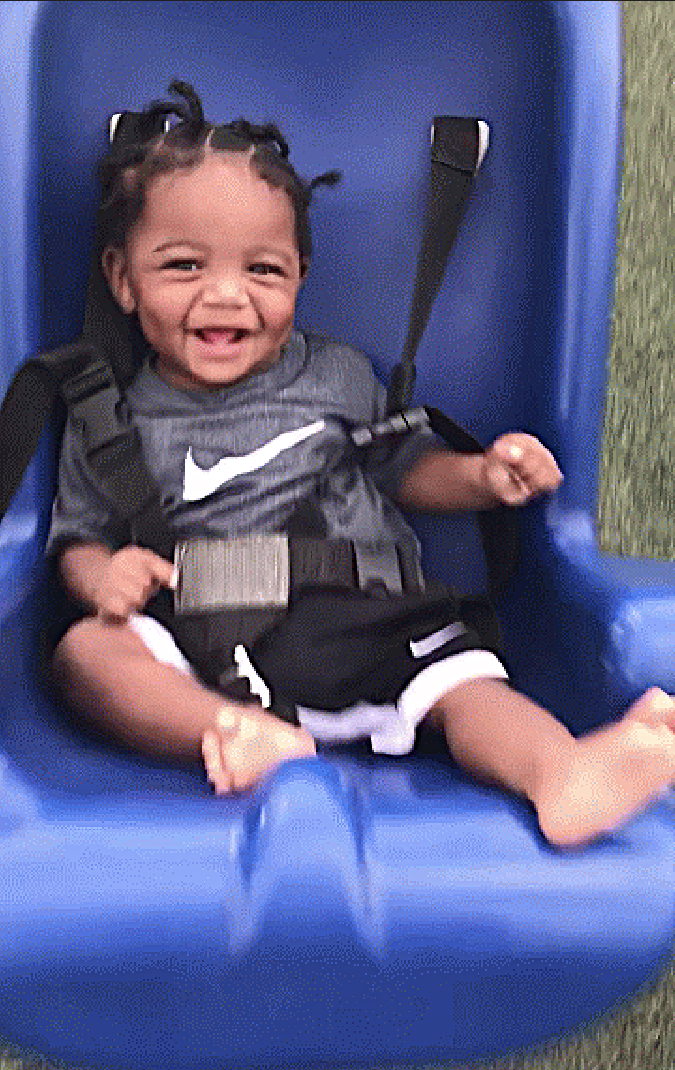 Smiling baby in a blue swing seat